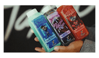 a person is holding three bottles of liquid in front of a black background