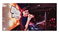 a young man with dj equipment in front of a stage