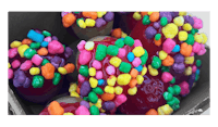 a box filled with colorful sprinkles and candy apples